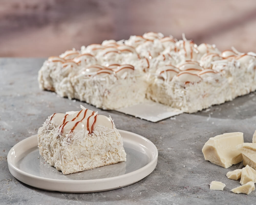 Yoğun beyaz çikolata kreması ve kıtır kıtır profiterol toplarının özel pasta sosuyla kaplandığı karamel tadında enfes pasta​​​​​​​